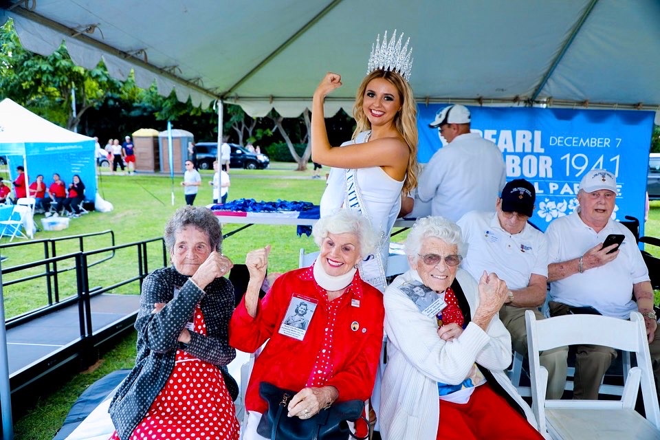 Lily K. Donaldson and three women who worked in shipyards during WW2 hold up their arms like Rosie the Riveter