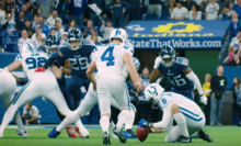 Vinatieri walking up to the kicker, shot from behind