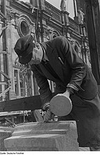 A left-handed stonemason with mallet and chisel