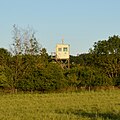 Der hintere Wachtturm aus Stahl wird bereits von Bäumen überragt