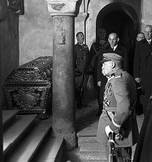 A man is standing, facing a staircase