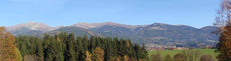 Panoráma východní části hřebene Seckauských Taur. Vlevo vrchol Seckauer Zinken, vpravo vrchol Hochalm (s poutním kostelem), vpravo dole vesnice Seckau.