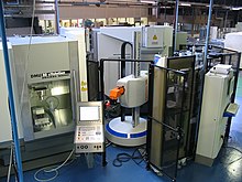 Large automated milling machines inside a big warehouse-style lab room