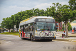 A white bus with a bicycle in front