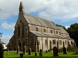 19th century stone church with side aisles and bell gable