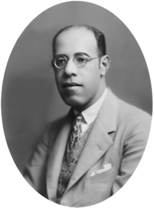 Black-and-white photograph showing the head and shoulders of Andrade. He is a middle-aged man with glasses wearing a suit.