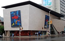 Bata Shoe Museum on the corner of a street in Toronto. People walking on the sidewalk in front of the facade.