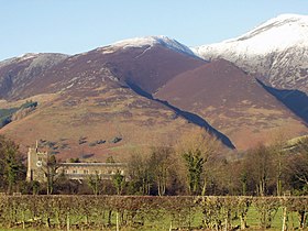 Old village church with a backdrop of snow-capped fells