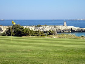 Trou n° 16 du golf de Sperone.La construction visible en arrière-plan est « l'éperon » (sperone en langue corse), qui a donné son nom au lieu.