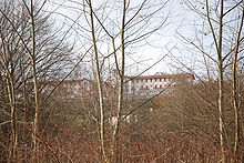 Vue de deux corps de bâtiments sur le haut d’une colline.