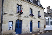 Photographie en couleurs d'un bâtiment à étage avec l'inscription MAIRIE gravée au-dessus d'une porte.