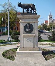 Statuia „Lupa Capitolina" (Statuia Lupoaicei). În spate Biserica romano-catolică „Adormirea Maicii Domnului”