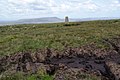 Trig point at the summit with Pendle Hill in the background.