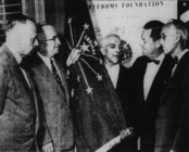 Supreme Court Justice James Emmert and Mayor gar Stahl gather around the state flag presented at a Freedoms Foundation exhibit opened at Manual High School, 1955.