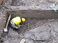 Archeoloog bij de muur van een boerderij