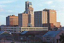 The Lamar Building, a skyscraper with a pyramidal penthouse, as seen from a distance, with buildings on either side.