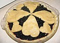 A blackberry pie with a crust design of hearts on the top