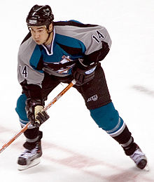 Photographie de Jonathan Cheechoo avec un bleu-gris de hockey