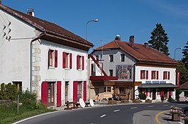 Hotel Arbez in La Cure. The border runs lengthwise through the two buildings, passing just to the left of the mural. The mural and everything to the right of it lies in Switzerland; France lies to the left.