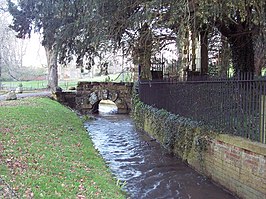 Het riviertje Tarrant langs het hek van een landhuis