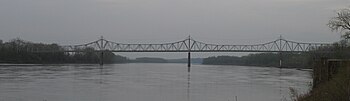 A graceful truss bridge over a broad river.