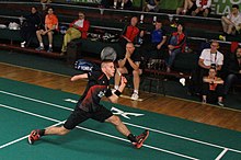 A para-badminton player trying to hit the shuttlecock