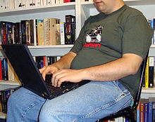 A man using a laptop which is placed above his groin. The heat from the laptop may interfere with the quality of his semen.