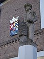 Kapelle: blason sur la mairie et statue du cultivateur de fruits