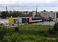 Het terrein van de supermarkt, met op de achtergrond de torens van de oude binnenstad