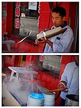 Cutting thin strips of dough from a loaf directly into a container of boiling water to make knife-cut noodles in Datong, Shanxi