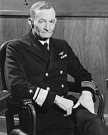 Black and white photograph of an old seated man wearing a formal naval uniform