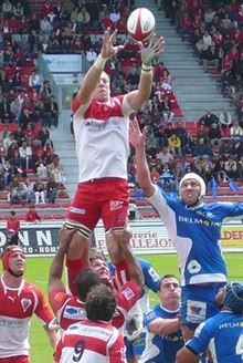 Imanol Harinordoquy, soulevé par des coéquipiers, captant à deux mains la balle en touches.