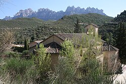 A ilesia de Sant Esteban de Marganell, con Montserrat a o fondo