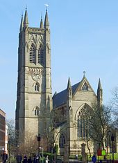 A Gothic Revival church showing its tower on the left, and the east end on the right