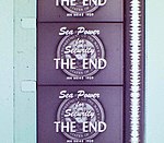 Vertical section of filmstrip, showing four-and-a-half frames, each of which reads, "Sea Power for Security. The End." Alongside the frames runs a continuous vertical white band of continuously fluctuating width.