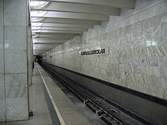 De stationsnaam op de marmeren bekleding van de tunnelwand