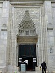 La entrada a la mezquita, con un portal de mocárabes tallados.