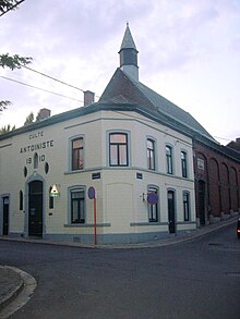 Bâtiment à la façade couleur crème, situé à l'angle de deux rues