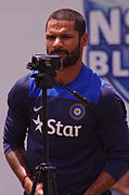 A man wearing a dark-blue shirt and standing near camera.