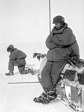 Douglas Mawson se reposant contre un traîneau.