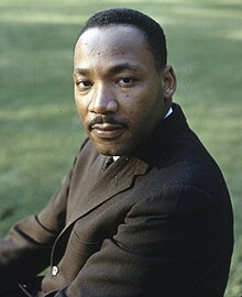 Color portrait of Martin Luther King Jr. wearing a suit