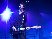 A man playing a guitar and singing.