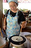 The batter for khao phan, as the noodle roll is called in Thailand, is spread out over a cloth stretched over a pot of boiling water.