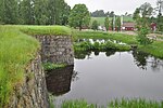 Ruinens norra del med laxodlingen i bakgrunden.