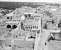 The houses of Qatif Castle are located amidst lush palm trees, with a vast ocean extending beyond the horizon. This photograph was taken from within the confines of Qatif Castle, although the exact date of capture remains uncertain.