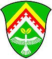 a chevron enhanced - Vert; a chevron enhanced, per chevron or and argent, over the partition line another, the lower edge dovetailed, gules, in base a dove ascending argent, holding in its beak two leaves or - Kwnanonzame Town Committee, RSA