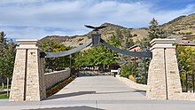 An image of a gate, with stone pillars and an eagle statue on top.