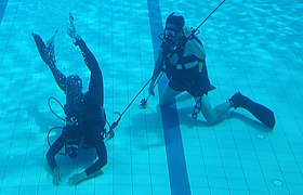 An American pararescueman from the 320th Special Tactics Squadron watches a Paskau member of the Royal Malaysian Air Force conduct a search pattern during an underwater search and recovery course.