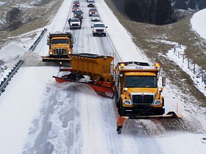 Trucks plowing snow on a highway in Indiana.