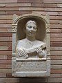 Estela conmemorativa de una mujer romana de 16 años, representada tocando un instrumento tipo pandura, fecha estimada del siglo II d.C. Desenterrada en 1956 en el sitio arqueológico Emerita Augusta en España. Conservada en el Museo Nacional de Arte Romano de Mérida, España[8]​